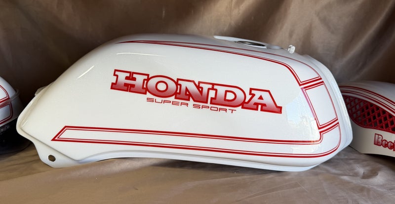 CB400のガソリンタンク。白地に赤い二重ラインとHONDA SUPER SPORTの文字を配したカスタムペイント