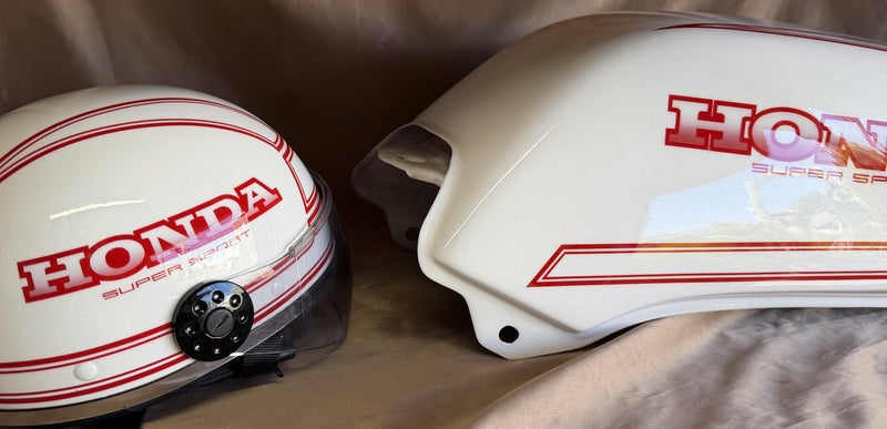 白と赤で配色をそろえたヘルメットとCB400のガソリンタンク。両方にHONDA SUPER SPORTの文字