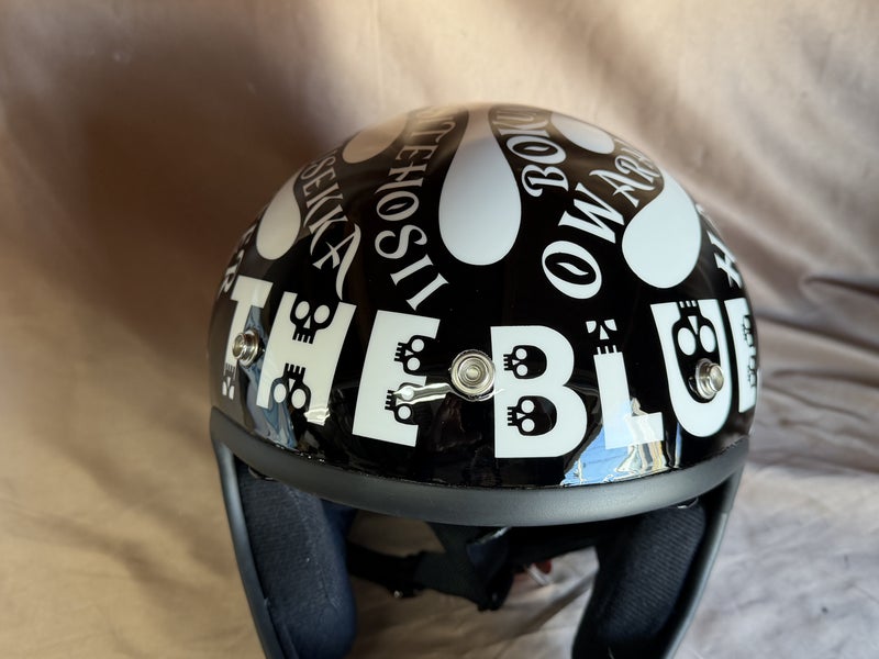 ヘルメットの正面に白い大きな文字と小さなスカルを配置した実作品写真
