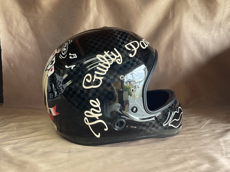カーボン柄とクリーム色のレタリング、口元の唇モチーフが見えるヘルメット側面の実作品写真