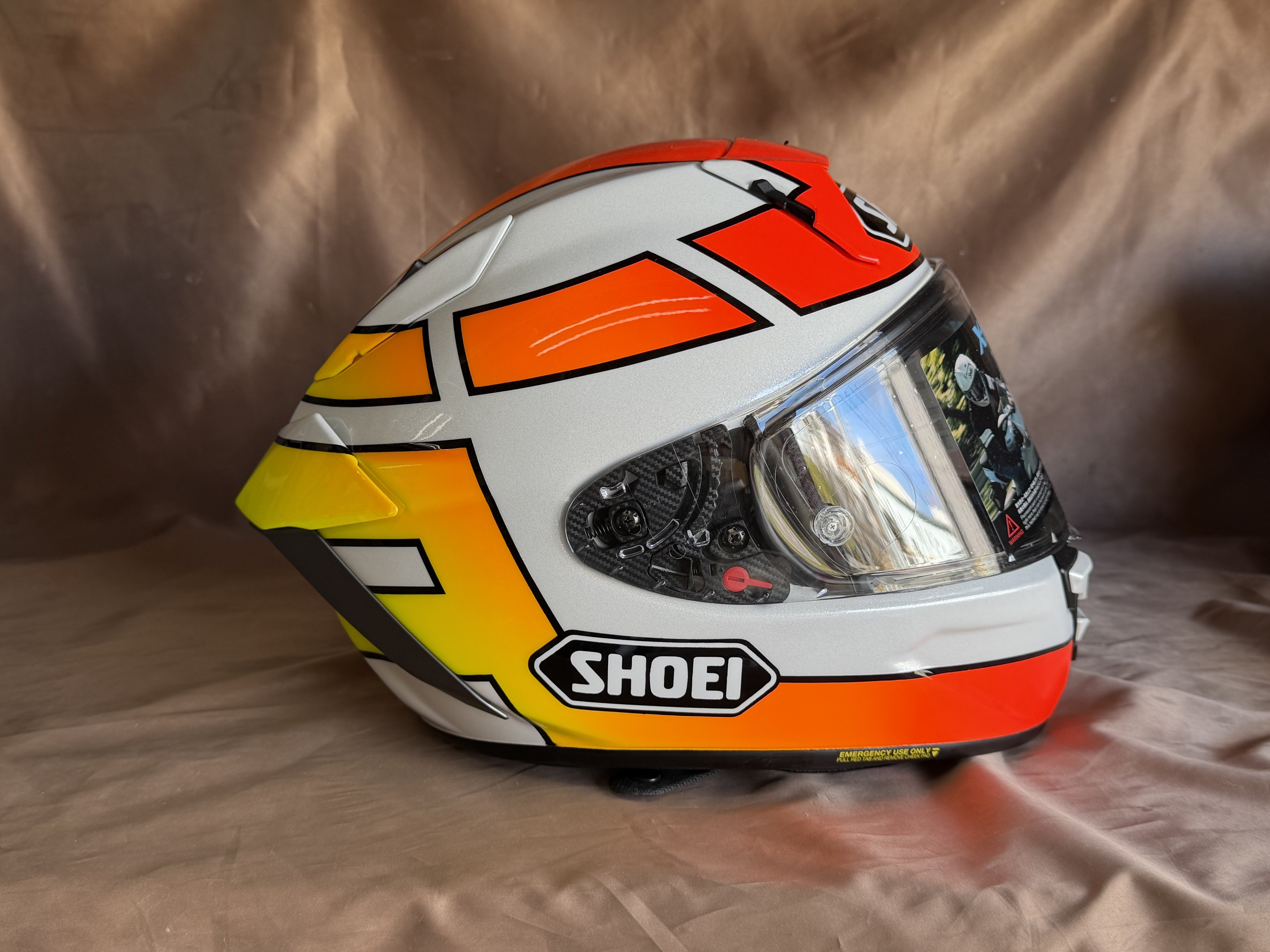 白系のSHOEI X15に黒い縁取りと赤・オレンジ・黄色のグラデーションを配したグンヘルデザイン